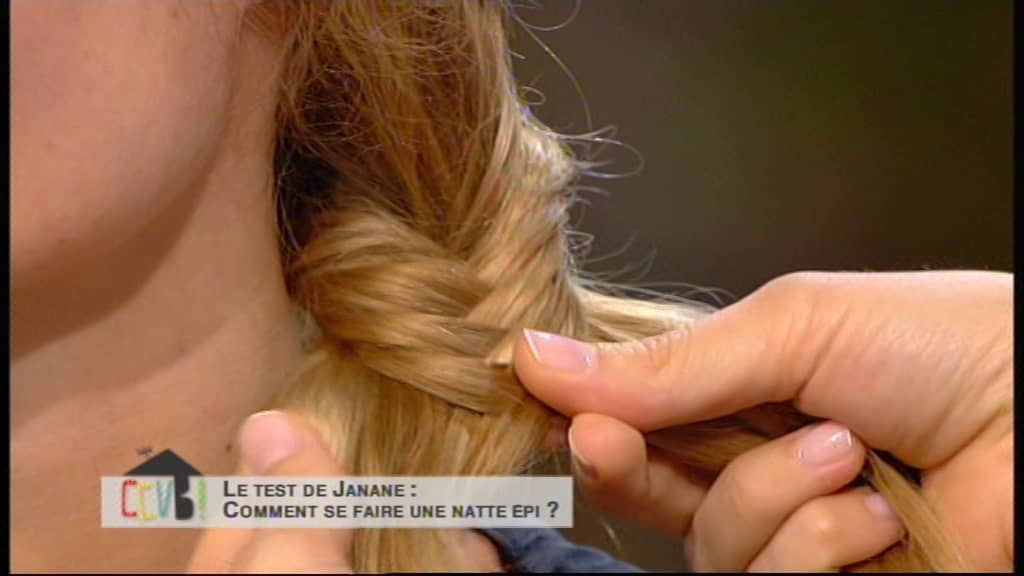 femme réalise un chignon pour une Tendance coiffure femme. Elle est blonde avec un diadème dans les cheveux et on voit sa tresse de près