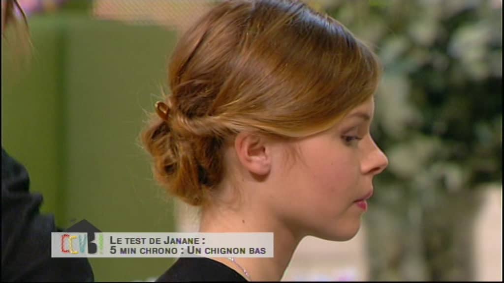 femme de profil réalise un chignon pour une Tendance coiffure femme. Elle est blonde avec un noeud dans les cheveux