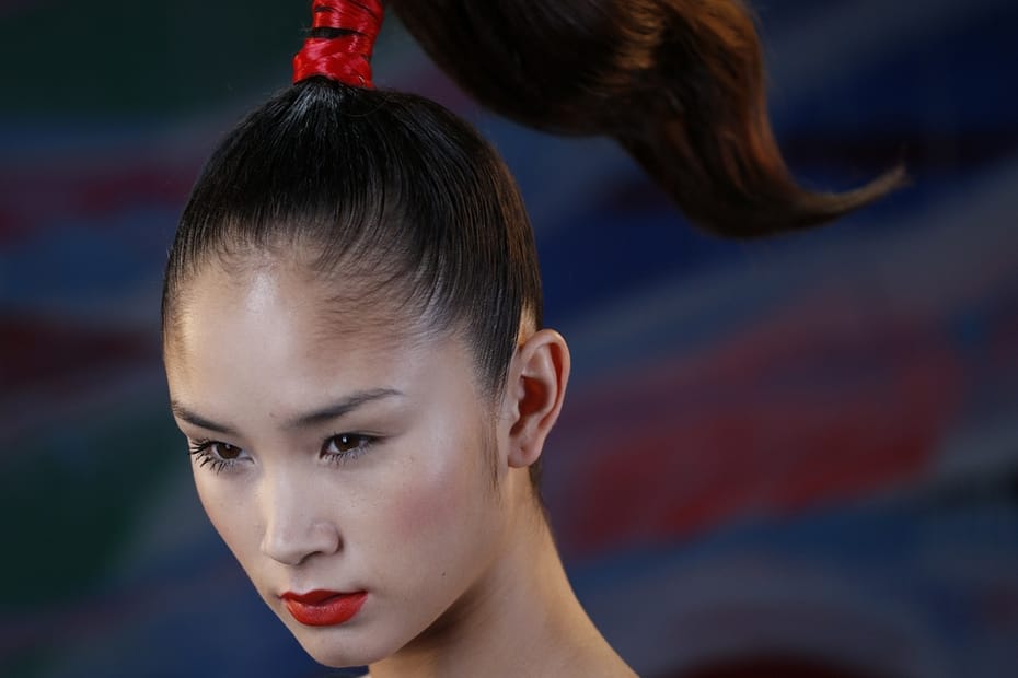 une queue de cheval dressée sur le dessus de tête liée par un bandeau de cheveux rouge, inspiré des pinceau,’ japonais